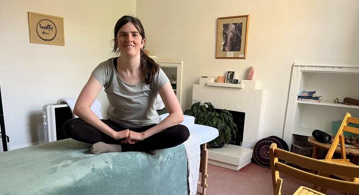 Jo Craven massage therapist sitting on massage table