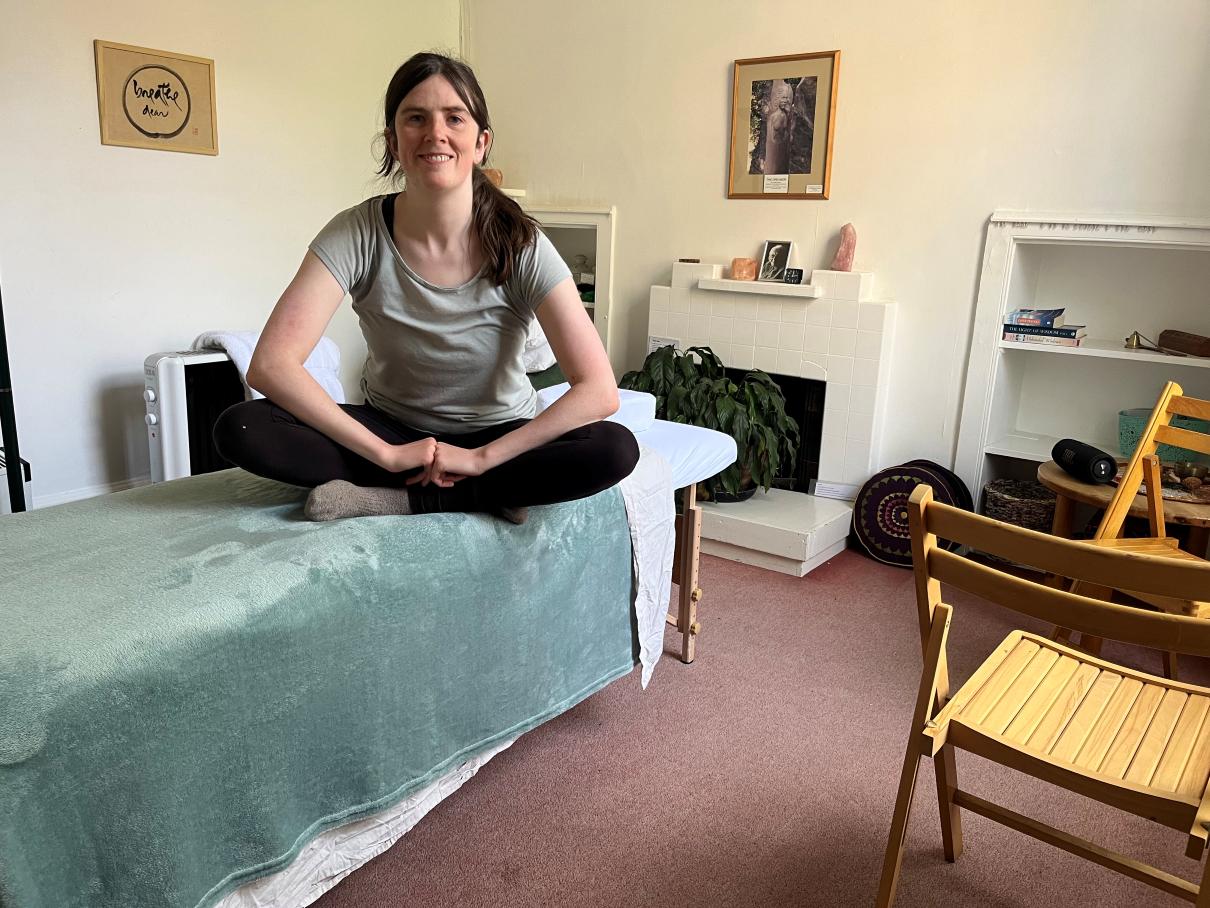 Jo Craven massage therapist sitting on massage table
